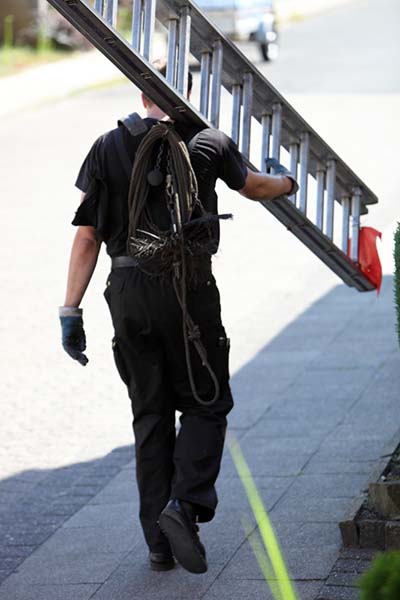 Chimney tech carrying ladder - Advance Chimney Chimney tech carrying ladder down the street